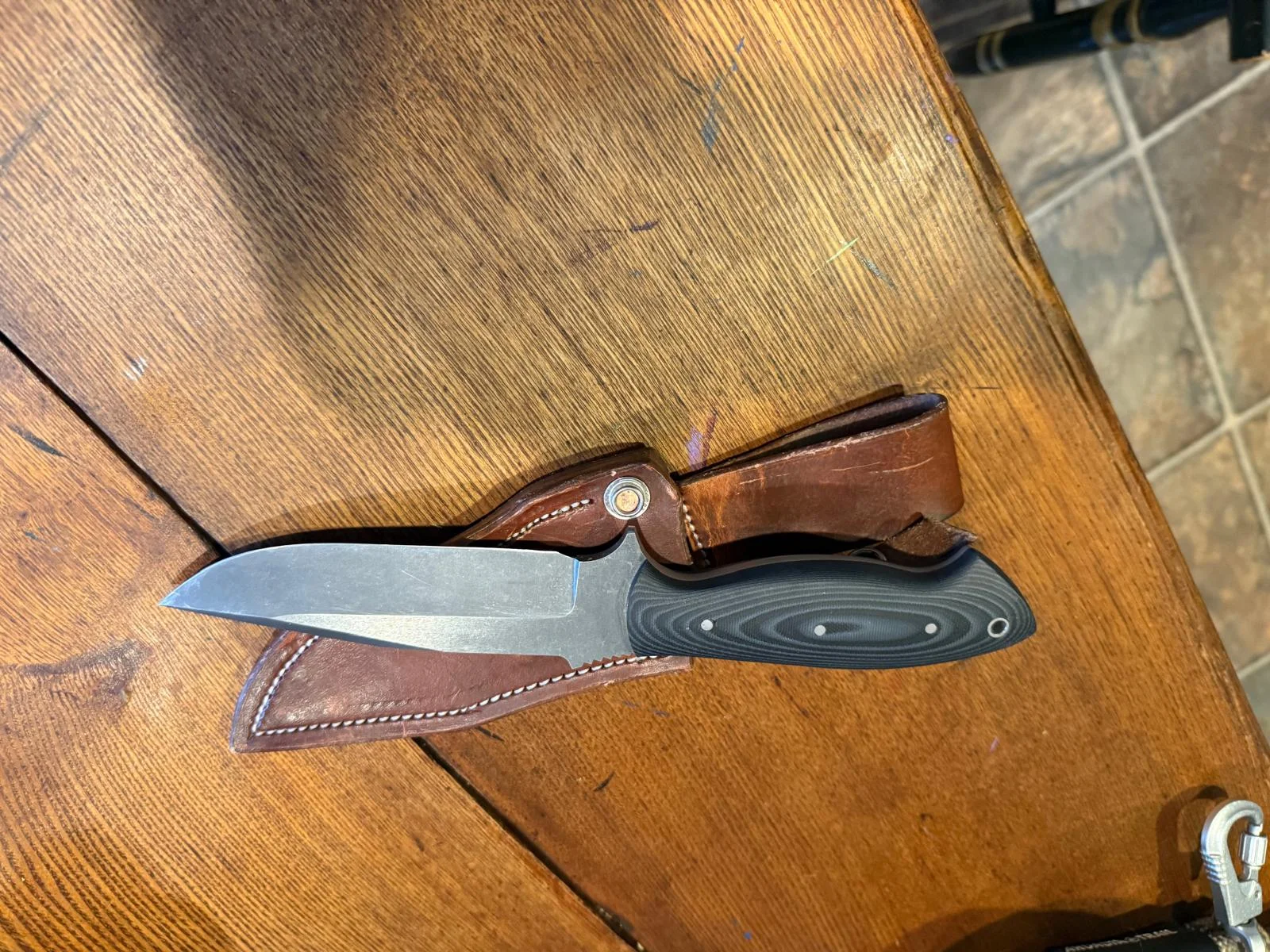 The Huntfishdine Tony Baker Walking around knife is made from acid-washed 3/16 SV90 blade stock, which holds an edge extremely well. Handle material is Black and Grey Micarta. Overall Blade length is 5 9/16” : Cutting surface is 4 5/8” Clip Point. Finger choil and jimped thumb ramp. Comes with a heavy-duty handmade sheath. This is a limited-edition run in SV90 steel; only 12 will be made. I have the 1st, so Thirteen in Total. These are once-in-a-lifetime knives, and you will not be disappointed.